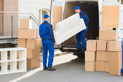 Furniture being carried carefully down stairs during a flat move in Penge